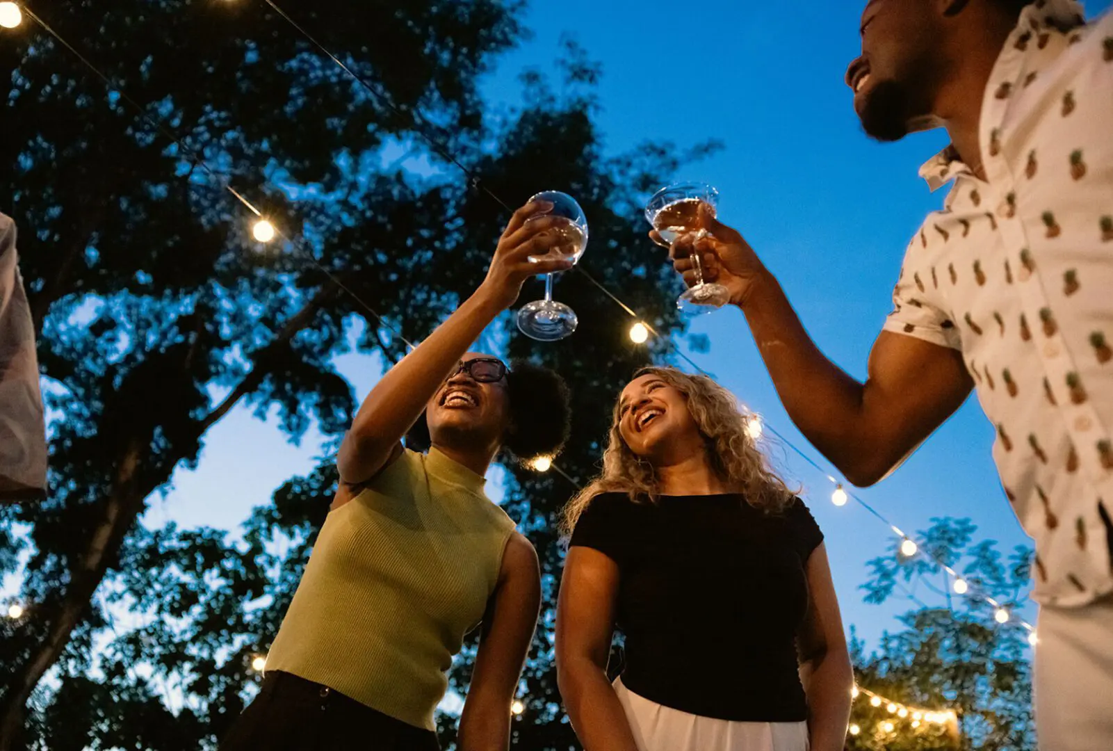 People enjoying outdoor evening gathering with drinks.