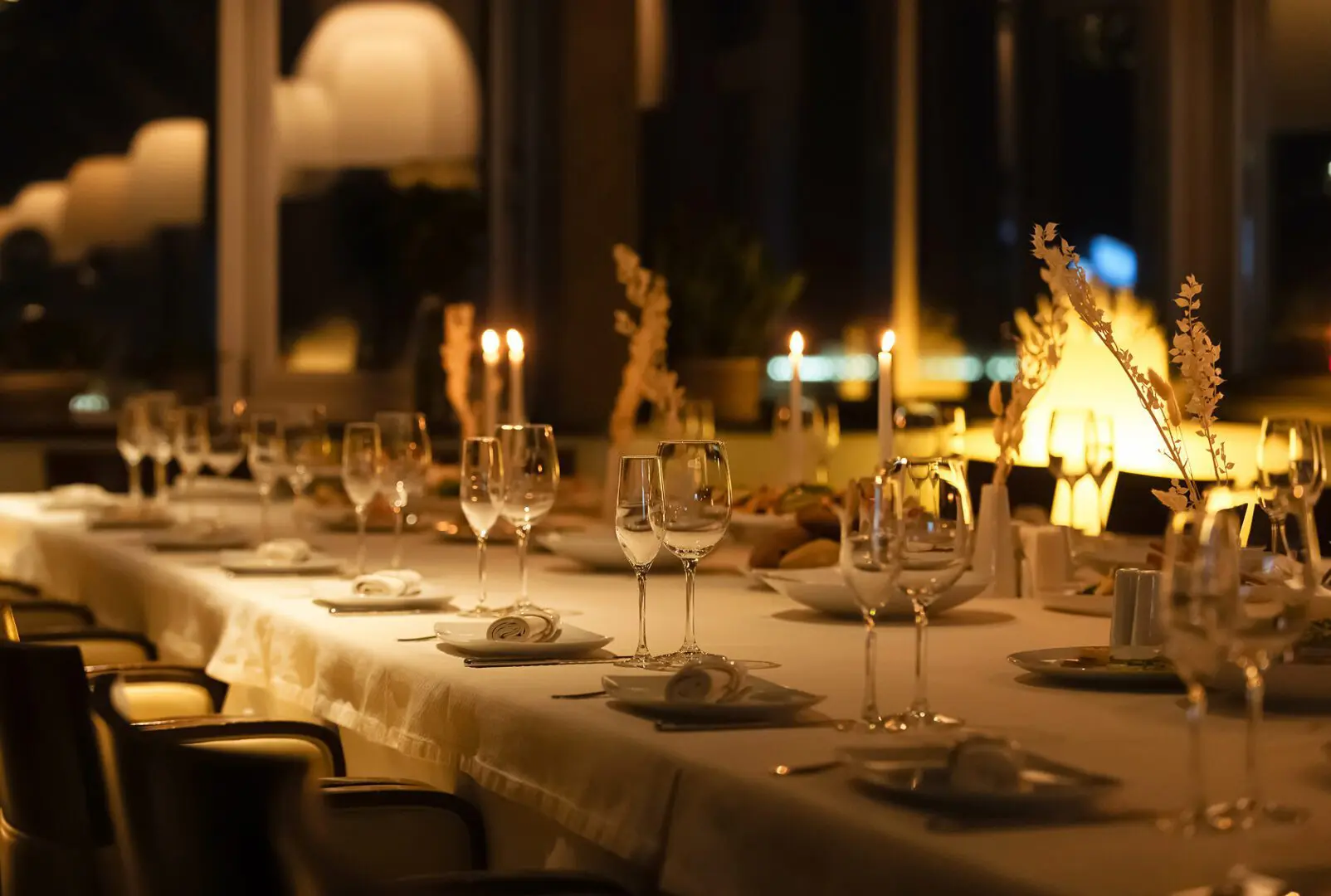 Elegant dining table with candles and glasses.