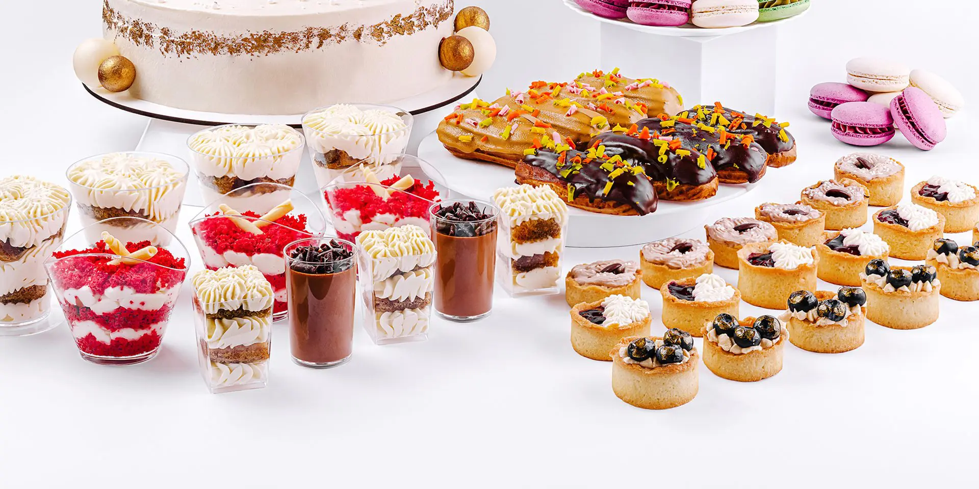 Assorted desserts including cake, eclairs, macarons.